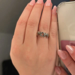 Silverring med texten MOM - Snygg ring i silverfärgat material med texten 'MOM' framtill. 