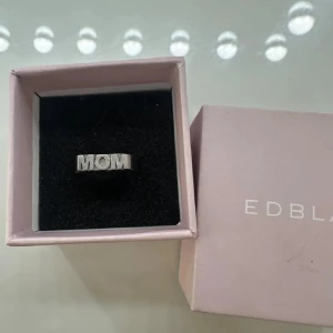 Silverring med texten MOM från Edblad - Säljer en stilren silverring från Edblad med texten MOM i blockbokstäver. Ringen levereras i original ask och är perfekt som present till någon speciell.