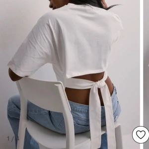 Vit topp med knytning  - Jätte fin vit topp från Nelly som har knytning i ryggen. Endast använt ett fåtal ggr o har därmed inga defekter. Perfekt nu till sommaren !! Nypris: 249 kr