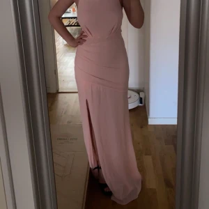 Ljusrosa balklänning med öppen rygg - Säljer min balklänning som endast är använd 1 gång och därför är den som ny! Den är köpt på Asos för 609kr. Som referens är jag 163cm lång och klänningen är enda till marken på mig med klackar!🩷🥂