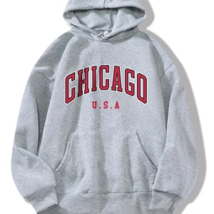 Grå Chicago-hoodie - Säljer en grå hoodie med rött 'CHICAGO U.S.A' tryck på framsidan. Den har en klassisk känguruficka och en bekväm huva med mjuk bomull på insidan. Perfekt för en avslappnad stil och är endast använd ett fåtal gånger. 