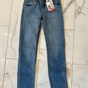 Levi's 510 Skinny Jeans - Snygga Levi's 510 skinny jeans i en klassisk blå färg. Dessa jeans har en smal passform och är tillverkade i stretchmaterial för extra komfort. Perfekta för en stilren look. Helt oanvända. Storlek 12 År. 