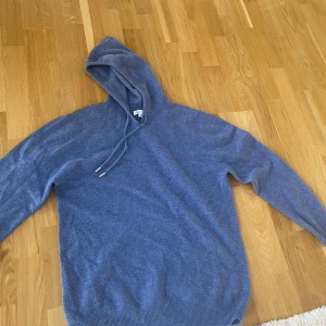Blå Kashmir hoodie - Säljer en snygg blå kashmir hoodie från garde grisch. Den ända riktiga defekten är där i kragen men det syns knappast