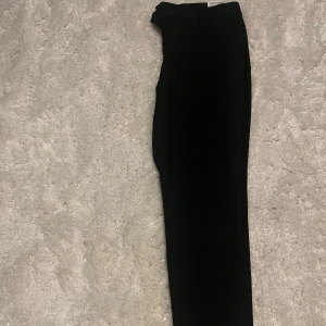 Svarta kostymbyxor från Jack & Jones 33/32 - Snygga svarta kostymbyxor/chinos från Jack & Jones med slim passform. Perfekta för en stilren look. Byxorna har en klassisk design och är tillverkade i ett bekvämt material.