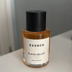 Essnce Black Velvet Eau de Parfum - Säljer en oanvänd parfym. Elegant flaska av Essnce Black Velvet Eau de Parfum. Flaskan är cylindrisk med en svart kork och en stilren etikett. Doften är förmodligen djup och mystisk, perfekt för den som gillar en sofistikerad parfym.