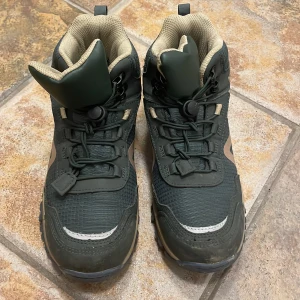 Kraftiga kängor str 34 (vinter, vandringssko) - Säljer ett par robusta gröna kängor med beige detaljer och snörning. Perfekta för utomhusaktiviteter med en slitstark sula och vadderad insida för extra komfort. Waterproof. Använt 1 gång.