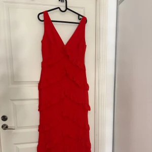 Röd balklänning med volanger - Säljer denna super fina balklänning med prislappen kvar! Aldrig använd så helt utan defekter. Köpt på Pretty Lavish för 1500kr. Jag är 163cm lång och den är enda ner till marken med klackar!❤️