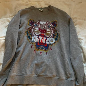 Kenzo sweatshirt  - Grå sweatshirt med en broderad tiger på framsidan. Tröjan har en rund halsringning och långa ärmar. Storlek S och är i bra skick. Nypris ligger runt 2300.
