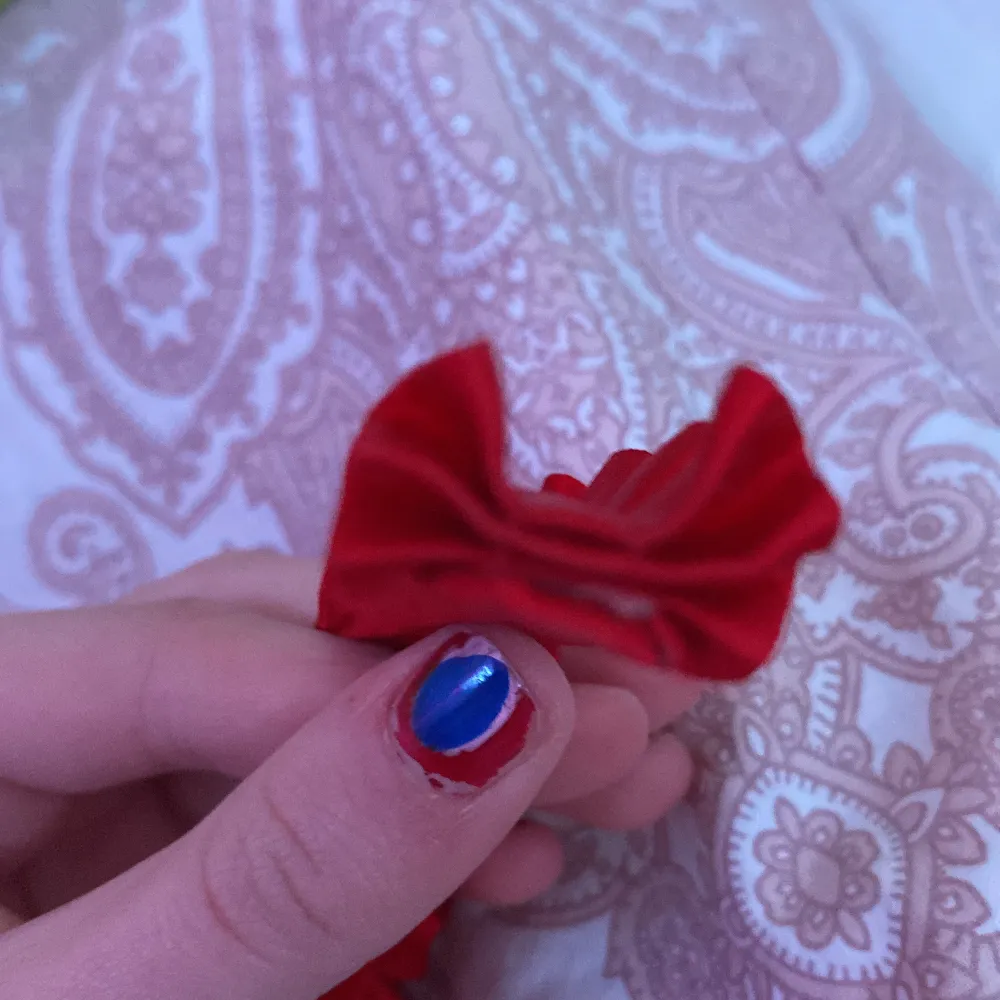 Snyggt rött diadem med dekorativa rosetter längs hela kanten. Perfekt för att ge en färgklick till din outfit. Jätte snyggt att ha på tillexempel jul! Tillverkat i ett mjukt material som ger en bekväm passform. Ignorera mina naglar haha men jag vet inte riktigt vart diademet kommer ifrån och hur använt det är men jag tycker det ser oanvänt ut. Men ni får såklart skriva för mer bilder och information. . Asusteet.