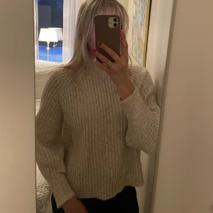 Melerad ribbad stickad tröja - mysig melerad stickad tröja med ribbad struktur. Tröjan har långa ärmar och en hög krage 🌸