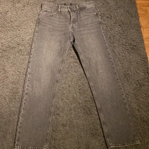 Grå jeans från Jack & Jones - Snygga grå jeans från Jack & Jones med en relaxed fit. De har en klassisk femficksdesign och är perfekta för en avslappnad stil. Säljer de pågrund av att dom inte passar mig i midjan längre riktigt fint skick nästan aldrig använda köptes i julas för 600kr säljer nu för 250kr pris kan diskuteras vid snabb affär det är storlek 29/32 passar perfekt för dig som är 175-180 cm lång 