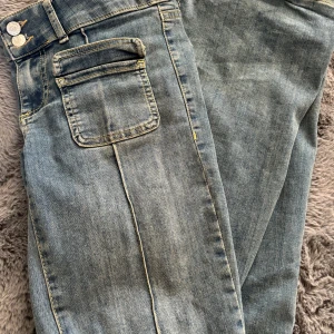 Blå jeans med bootcut - Snygga blå jeans med bootcut-stil och klassisk femficksdesign. Köpta på nellys hemsida och är slutsålda där nu, strlk 34, lite slitna längst ner annars mycket bra skick