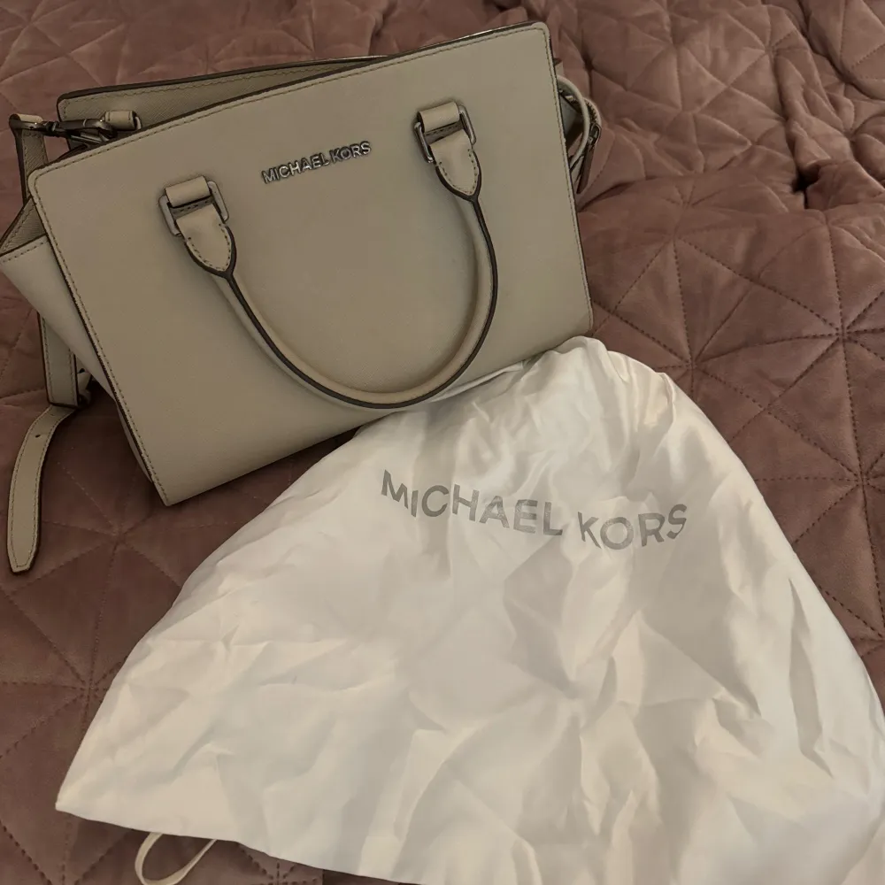 Äkta michael kors väska i måtten ca 28cm bredd, 18cm höjd. Har både handtag och axelrem, funkar som handväska och axelväska. Användes någon period några år sen, har sedan bara legat i garderoben. Är i bra skick, små tecken på användning om man kollar noggrant. . Laukut & Käsilaukut.