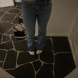 blå lågmidjade jeans - Snygga blå jeans med en klassisk straight fit och dubbla knappar i midjan. Perfekta för en avslappnad stil. De har en normal passform och är tillverkade i jeansmaterial. De är uppsprättade där nere för att de skulle passa mig som är 172 cm. De är i storlek 38 men skulle säga att de passar bättre 36.💞