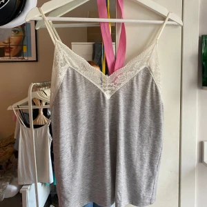 Linne med spets - Jättefint grått linne med vit spets från Lindex. Använd mycket men i super fint skick. Köpt för 250 kr