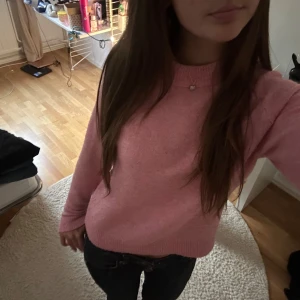 Rosa stickad tröja med rund hals - Mysig rosa stickad tröja med rund halsringning och ribbade muddar vid ärmslut och nederkant. Perfekt för dig som gillar en enkel men söt stil. Långärmad och i en normal passform som funkar till det mesta.