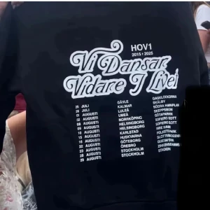 Svart Hov1 hoodie Vi Dansar Vidare - ❗️SÖKER❗️Svart hoodie från Hov1 med stor vit text 'Vi Dansar Vidare I Livet' och turnédatum på ryggen. Stl s/36