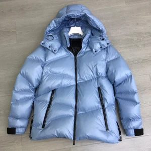 Moncler Yonne Shell Jacket - Säljer en sjukt snygg ljusblå dunjacka från Moncler med stor huva och svarta detaljer. Jackan har dragkedja framtill, två snedställda fickor med dragkedja och breda svarta muddar vid ärmsluten. Perfekt för kalla dagar när du vill vara både varm och stilren. Kontakta via Snapchat: maisonla_drippo för eventuella rabatter på denna produkt