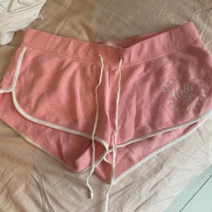 Rosa shorts från Hollister XS - Snygga rosa shorts från Hollister i mjuk bomullsfrotté. De har vit kant, snörning i midjan och tryckt logga på ena benet 