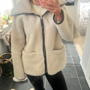 Beige teddyjacka från ARKET - Supermjuk och fluffig teddyjacka från ARKET i beige med dragkedja framtill och stora fickor. Jackan har en liten fläck på insidan men syns knappt 💖kan diskutera pris 