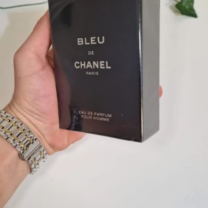 Bleu de Chanel Eau de Parfum - Säljer en elegant och tidlös Bleu de Chanel Eau de Parfum pour homme. Den kommer i en stilren mörkblå förpackning med vita bokstäver. Perfekt för den som vill ha en sofistikerad och maskulin doft. Flaskan är förseglad och redo att användas.