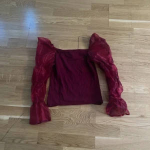 Vinröd topp med puffärmar från Primark size S - Säljer en vinröd topp från Primark med transparenta puffärmar 