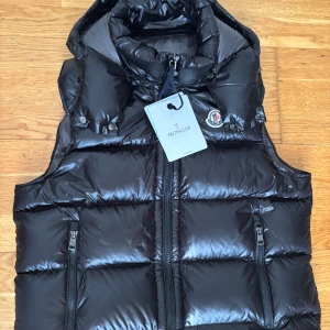 Svart väst från Moncler - Svart Bormes Hooded Down Gilet väst 10/10 sick, hör av dig vid snabba affär. Storlek M men sitter som storlek S.