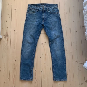 Blå jeans från Nudie Jeans - Hej! Ett par riktigt snygga Nudie jeans i fin ljusblå tvätt. Trendiga snygga små slitningar på framsidan som jag själv gjort. I övrigt är de i toppskick. Modellen är Lean Dean, storleken 31/30. Hör av dig vid frågor eller om du vill ha fler bilder! Pris kan diskuteras vid snabb affär