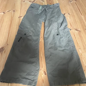 Gröna cargobyxor  - Snygga cargo byxor från Nikita med coola fickor! De har en fläck längs ner men inget som syns.