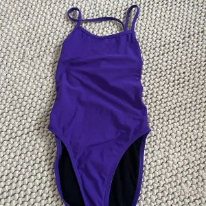 Lila baddräkt från Jolyn - Säljer en lila baddräkt från Jolyn med smala axelband som korsas i ryggen. Modellen heter 'Brandon 2'. Storlek 28. Bra skick. 