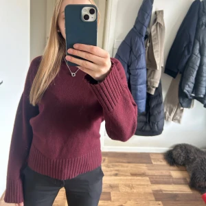Vinröd stickad tröja - Mysig vinröd stickad tröja med rund halsringning och breda ribbade muddar vid ärmslut. Tröjan är i nyskick och har används 2 gånger💕