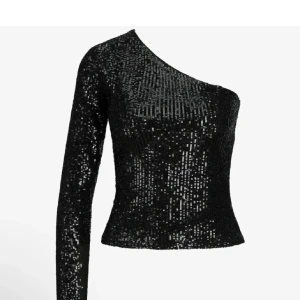 Svart glittrig oneshoulder topp - Snygg svart glittrig topp med oneshoulder-design. Perfekt för en kväll ute, med en tight passform. Endast använd ett par fåtal gånger.