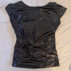 Glittrig svart topp - Topp från Zara med öppen rygg. Extremt snygg och perfekt för fest