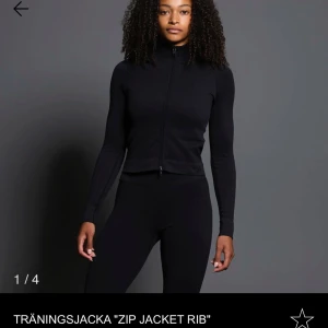 Svart träningsjacka 'Zip Jacket Rib' - Snygg och funktionell svart träningsjacka med dragkedja framtill. Jackan har en tight passform och är tillverkad i ribbat material för extra komfort. Perfekt för träning och aktiva dagar.