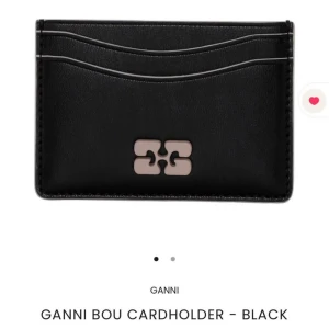 Svart korthållare från Ganni - Säljer en stilren svart korthållare från Ganni med diskret logga i metall på framsidan. Korthållaren har flera fack för kort och är perfekt för dig som vill ha ett smidigt och snyggt tillbehör i väskan. Jättebra och fint skick