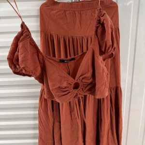 Rostbrun kjol med matchande topp från Bik Bok - Superfin rostbrun två delars från Bik Bok med puffiga kortärmar och en snygg cut-out detalj framtill. Använd 1 gång för en photo shoot helt ny 