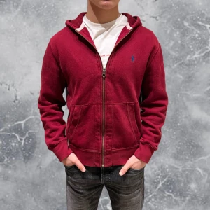 Ralph Lauren Full Zip Hoodie Röd - •Ralph Lauren full-zip hoodie mörk-röd. Skick: 8/10, Inga skador! Storlek: S, herr. Modell: 173 cm, 63 kg. Sitter bra på modellen på bild! Authentic: ✅. Hör av dig vid frågor eller funderingar, mvh Hessler’s;) 