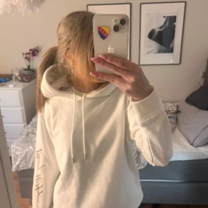 Vit hoodie från Tommy Hilfiger - Snygg vit hoodie från Tommy Hilfiger med deras signatur på ärmen och andra detaljer! passar verkligen till mycket. tröjan är ny med prislappen kvar. den har fått någon fläck vid luvan men det går att ta bort, vi vill bara inte göra det eftersom vi är tvungna att ta av lappen då! kan absolut tvätta om man vill innan postningen❤️❤️