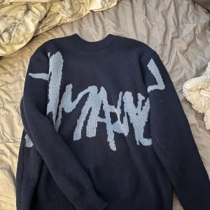 Stickad tröja med mönster - Säljer en mörk blå stickad tröja med ett abstrakt mönster. Tröjan har långa ärmar och en rund halsringning. Perfekt för kyliga dagar! Och sjukt stilren. Pris kan diskuteras.