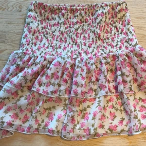 Kort Kjol/topp blommig rosa - Funkar utmärkt som både topp och kjol. Bara använt ett par gånger, som ny. Storlek 34 passar även 36.