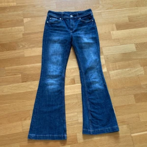Mörkblåa bootcut jeans - Säljer ett par snygga mörkblå, lågmidjade bootcut jeans från H&M med justerbar midja. Har bara användt ca 5 ggr. Vanligt jeans material.