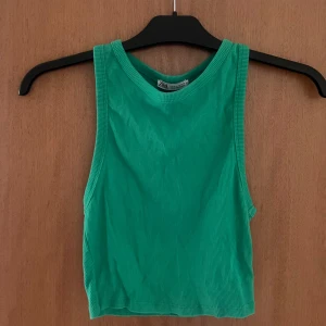 Grön ribbad linnetopp från Zara - Snygg grön ribbad linnetopp från Zara. Toppens material är mjukt och stretchigt för en bekväm passform.