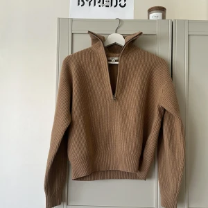 Beige stickad half zip-tröja från Uniqlo - Riktigt snygg beige stickad tröja från Uniqlo med ribbad struktur och hög krage. Tröjan har en half zip-dragkedja framtill och långa ärmar. Perfekt för lager-på-lager och chill höst- och vinterstil. Lite nopprig🎀 100% ull