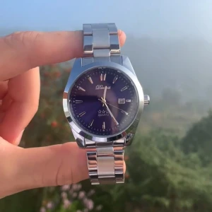 Silverfärgad Doventi klocka med blå urtavla - Stilren klocka från Doventi med blå urtavla och datumvisning. Armbandet är i blankt silverfärgat metall och har en klassisk länkdesign. Urtavlan är rund och har minimalistiska indexmarkeringar. Perfekt accessoar för dig som gillar en clean look.