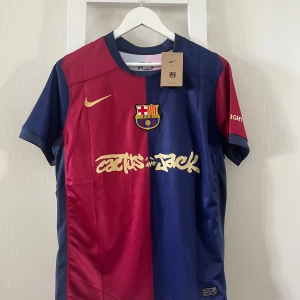 FC Barcelona Lamine Yamal tröja Nike M - FC Barcelona matchtröja från Nike i storlek M med Lamine Yamal och nummer 19 på ryggen. Tröjan är blå och röd med guldfärgade detaljer, klubbmärke på bröstet och tryckta sponsorer. Tillverkad i lätt och ventilerande material, perfekt för fotbollsfans.