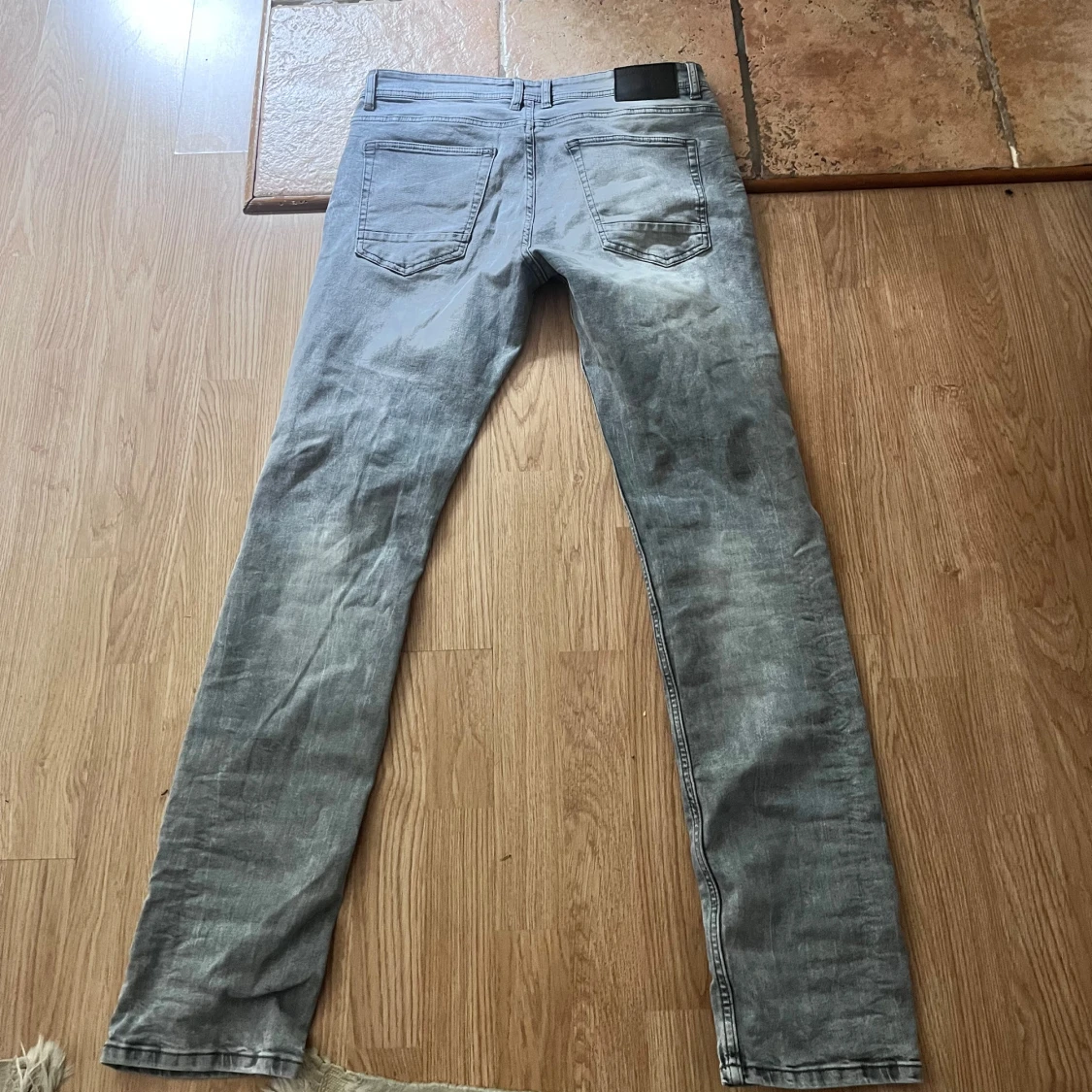 Gråa jeans med slitningar