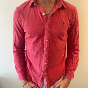Röd skjorta från Polo Ralph Lauren  - Snygg röd skjorta från Polo Ralph Lauren. Storlek M men skulle säga att den är lite mindre i storlek och passar mer S