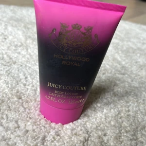Juicy Couture Hollywood Royal Body Lotion - Body lotion från Juicy Couture i serien Hollywood Royal. Tuben är svart och rosa med guldiga detaljer och rymmer 125 ml. Ger huden en lyxig känsla och doft, den är lite använd men nästan helt full. Perfekt för dig som gillar glam och vill ha en snygg produkt i badrumshyllan.