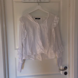 Vit sommrig blus från bik bok - De är en fin sommrig vit blus från bik bok i storlek M med mycket detaljer och går att knyta vid halsen om man vill 