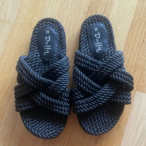 Svarta sandaler från Duffy  - Unika svarta sandaler från Duffy med cool repdesign och korsade band. Snygg struktur och riktigt sköna att glida runt i under varma dagar. 🌺